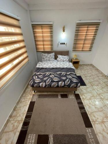 a bedroom with a bed in a room with windows at 2 Chambres Élégantes Confort Moderne in Santeo