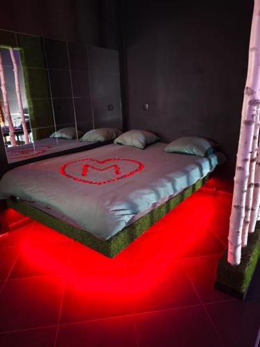 a bed with a heart drawn on it on a red floor at Suite love Jacuzzi in Charleroi