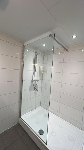 eine Dusche mit Glastür im Badezimmer in der Unterkunft Hotel Verhoeven in Uden