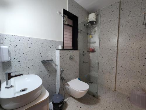 a bathroom with a sink and a toilet at Relaxed 1BHK Retreat - Pool, Balcony, Secure Parking, Walk to Candolim Beach in Candolim