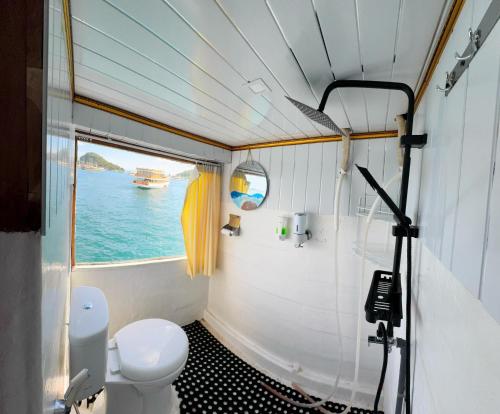 a bathroom with a toilet and a view of the ocean at Komodo Top Sailing in Labuan Bajo