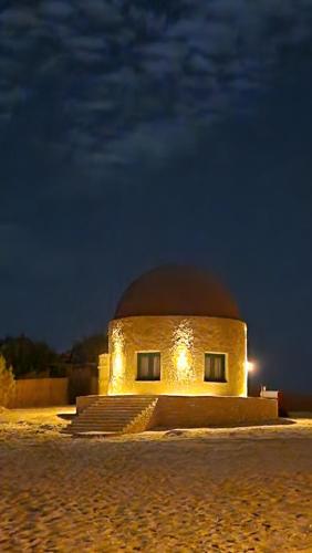 a building in the middle of the desert at night at moon retreat in ‘Izbat Mushandid al Kabīrah