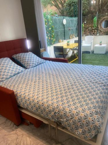 Bett in einem Schlafzimmer mit Blick auf eine Terrasse in der Unterkunft Charmant Studio in Cannes
