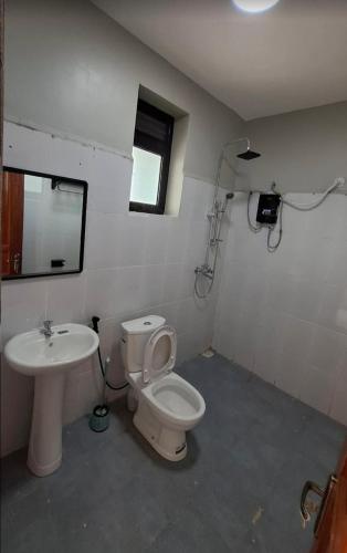 a bathroom with a toilet and a sink at Sqore Lounge in Gulu