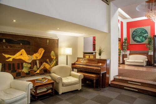a living room with a piano and chairs at Hotel Oxford in Rome