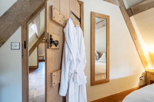 a robe hanging on a door in a bedroom at Coach House in Tolpuddle