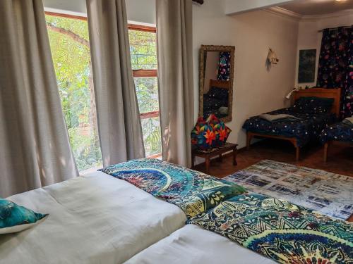 a bedroom with two beds and a window at A Jungle House in Somerset West