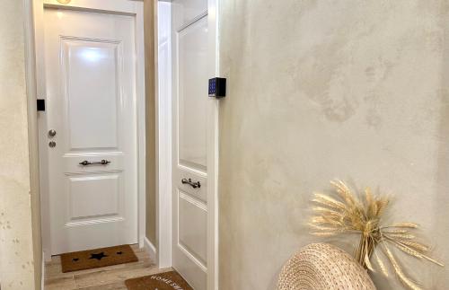 a hallway with a white door and a chair at Boutique apartment in heart of Haifa in Haifa