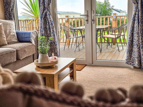 a living room with a couch and a table on a deck at Cornish Dream in Truro