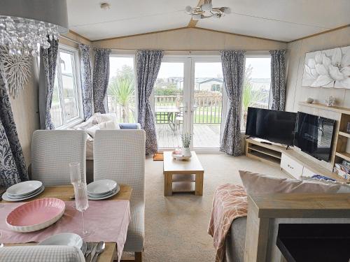 a living room with a couch and a table and a tv at Cornish Dream in Truro