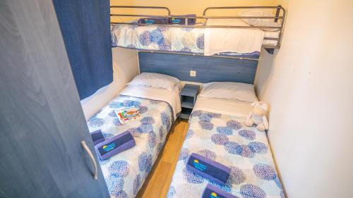 - 2 lits superposés dans une petite chambre dans l'établissement Happy Camp Mobile Homes in El-Bahira Camping Village, à San Vito Lo Capo