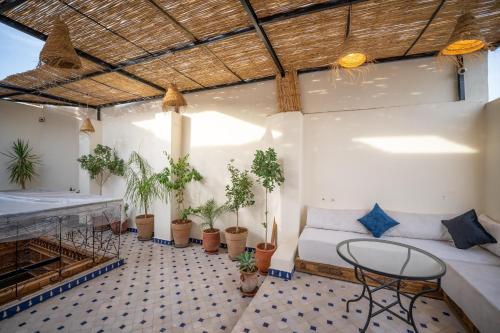 a room with a bed and potted plants on the floor at Riad Dar Sira in Fès