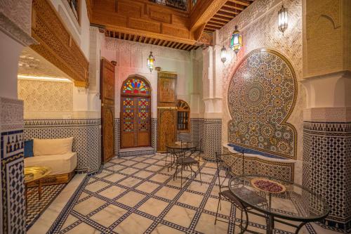 Habitación con suelo de baldosa, mesa y sillas. en Riad Dar Sira, en Fez