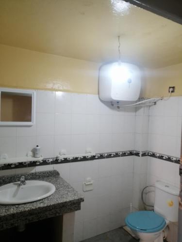 a bathroom with a sink and a toilet and a light at Dar Sofiane in Sidi Bouzid