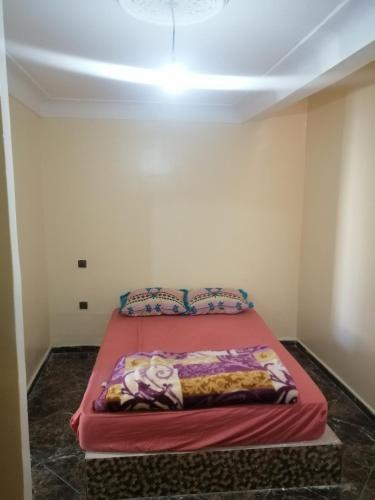 a bedroom with a red bed in a room at Dar Sofiane in Sidi Bouzid