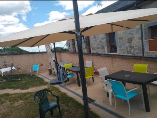 a group of tables and chairs under an umbrella at Albergue de peregrino Cruz de Fierro in Foncebadón