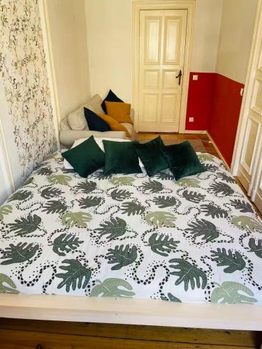 a bedroom with a bed with a green and white comforter at Cozy room with private balcony, center berlin in Berlin