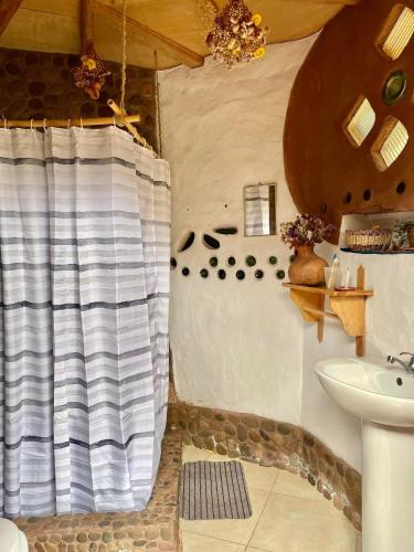 a bathroom with a shower curtain and a sink at Sevawasi in Cusco