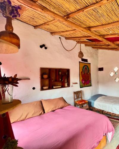 a bedroom with a bed and a wooden ceiling at Sevawasi in Cusco