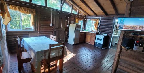 eine Küche mit Tisch und Fernseher in einer Kabine in der Unterkunft cabaña en el bosque in Valle Hermoso