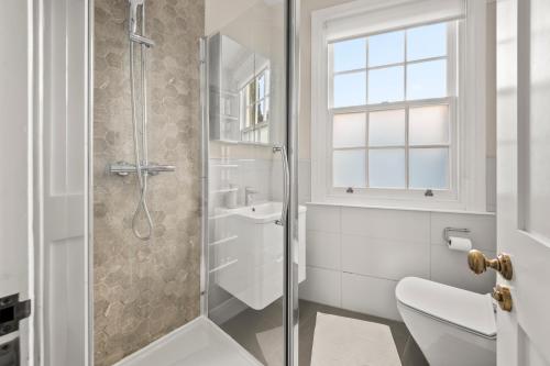 a bathroom with a shower and a toilet and a sink at Central Kings Cross modern house with free parking in London
