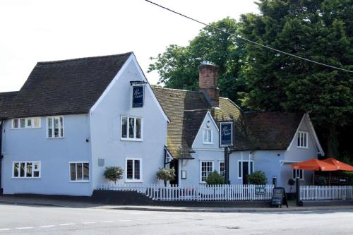a white house with a white fence in front of it at The Blue Anchor in Feering