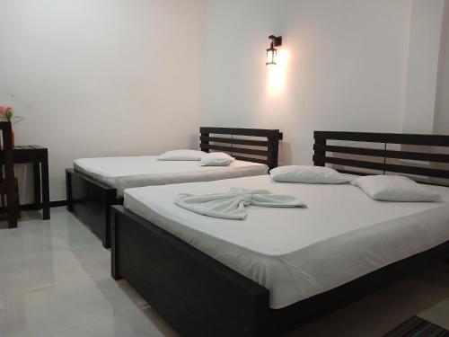 two beds sitting next to each other in a room at Yala Thaman in Kataragama