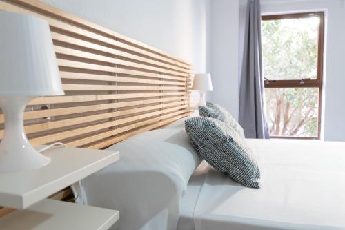 ein weißes Schlafzimmer mit einer Bank und einem Fenster in der Unterkunft Old Town La Estacion II in Alicante