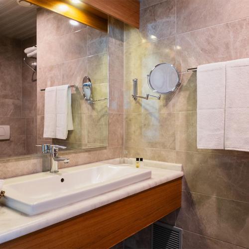 a bathroom with a sink and a mirror at Parion Hotel in Çanakkale