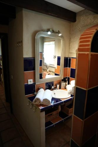 ein Badezimmer mit Waschbecken und Spiegel in der Unterkunft Appartement spacieux à Arles avec piscine et jardin partagé in Arles