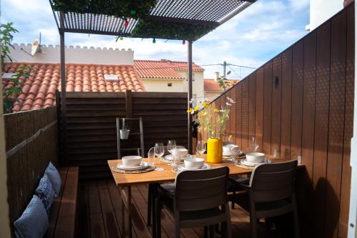 a wooden table and chairs on a patio at Magnifique appartement de style Catalan, au bord de la Plage du Grand Large pour location de vacances, de week-end, de nuité à Canet-en-Roussillon in Canet-en-Roussillon