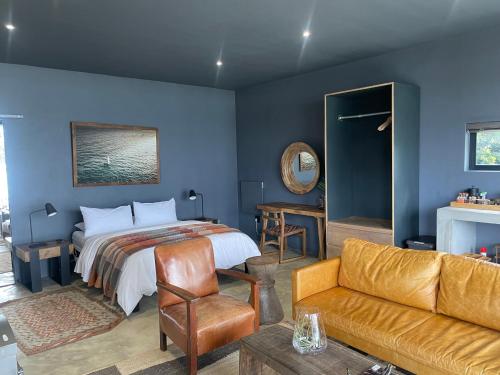 een slaapkamer met een bed en een bank bij Bellevue on the Knysna lagoon in Knysna