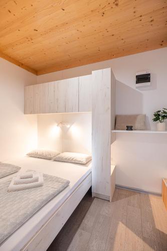 a bedroom with two beds and a wooden ceiling at Hiškovec - Holiday Village in Trebnje