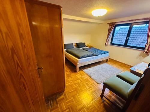 a bedroom with a bed and a couch and a window at Ferienwohnung Marie in Kurort Steinbach-Hallenberg