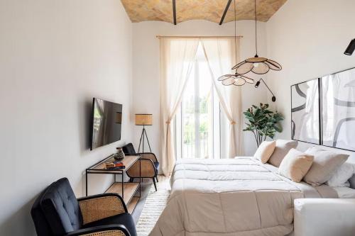 a bedroom with a bed and a chair and a window at Comfortable Lux apartments near the Colosseum - Rome in Courmayeur
