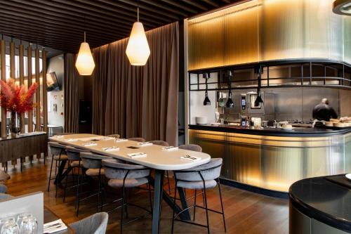 a restaurant with a long table and a kitchen at Radisson Collection Grand Place Brussels in Brussels
