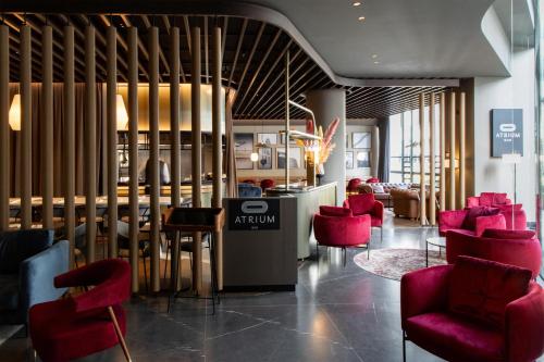 a lobby with red chairs and a table at Radisson Collection Grand Place Brussels in Brussels