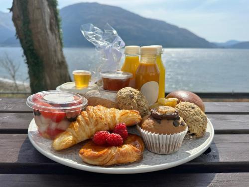 a plate of food with pastries and drinks on a table at Camus House, Lochside Guest House in Onich