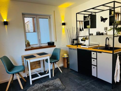 cocina con escritorio, 2 sillas y mesa en Appartement Little Rose, en Marktoberdorf