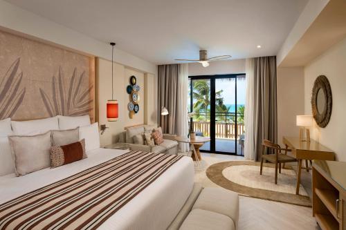 a hotel room with a large bed and a desk at Dreams Playa Esmeralda Resort & Spa - All Inclusive in Miches