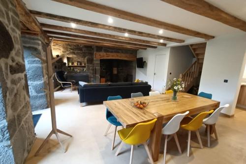 a dining room with a wooden table and chairs at Gîte pour 9 personnes avec jardin à proximité du Puy Mary in Le Claux