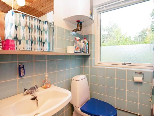 ein Badezimmer mit Waschbecken und Toilette und einem Fenster in der Unterkunft 4 person holiday home in Gedser in Gedser