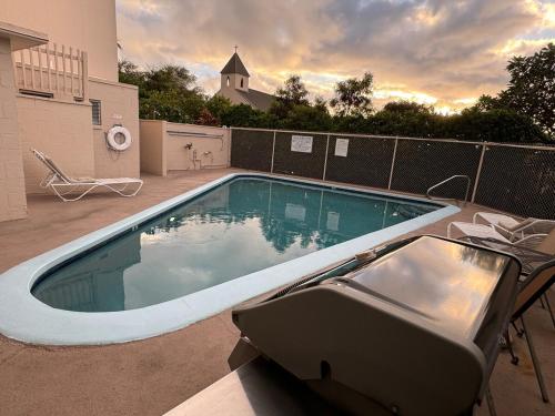 a swimming pool in a yard next to a building at Island Glow Kailua Village #508 free assigned parking, AC, downtown, walk to restaurants, bars and the pier in Kailua-Kona