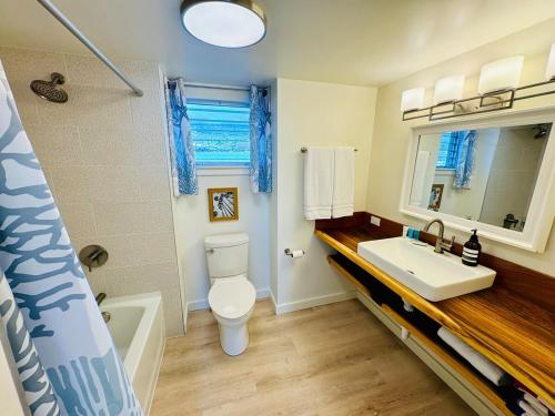 a bathroom with a white toilet and a sink at Island Glow Kailua Village #508 free assigned parking, AC, downtown, walk to restaurants, bars and the pier in Kailua-Kona
