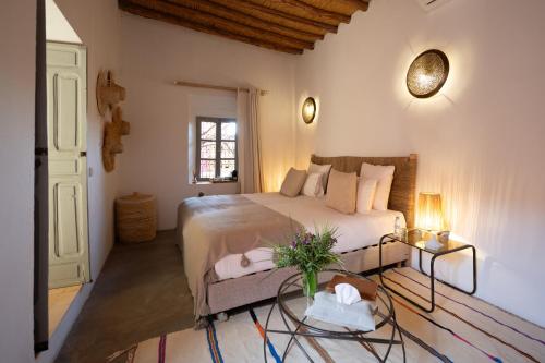 a bedroom with a bed and a glass table at Dar Syada Boutique Hotel Marrakech in Marrakech