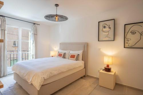 een slaapkamer met een bed met twee lampen en een raam bij AC Apartment with 1 Bedroom for 4 Guests - Place des lices of Saint-Tropez in Saint-Tropez