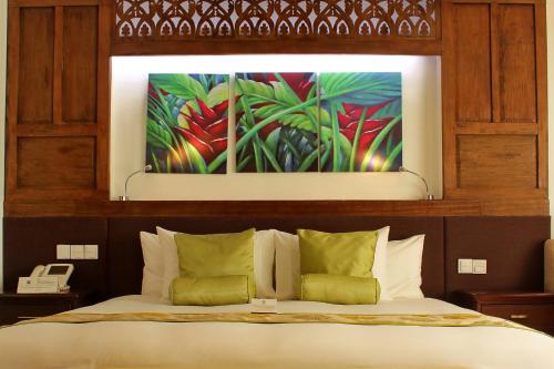 a bedroom with a bed with a painting above it at The Cocoon Boutique Hotel in Manila