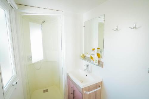 乌马格乌马格露营公园欢乐露营活动房屋露营地的一间白色浴室，配有洗手池和镜子。