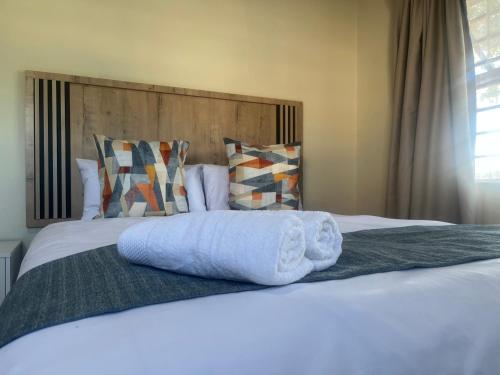 a bed with two towels on top of it at Sunray Guesthouse in Newcastle
