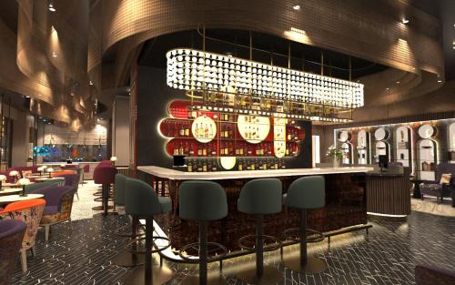 a bar in a restaurant with a chandelier at The Kensington Hideaway in London